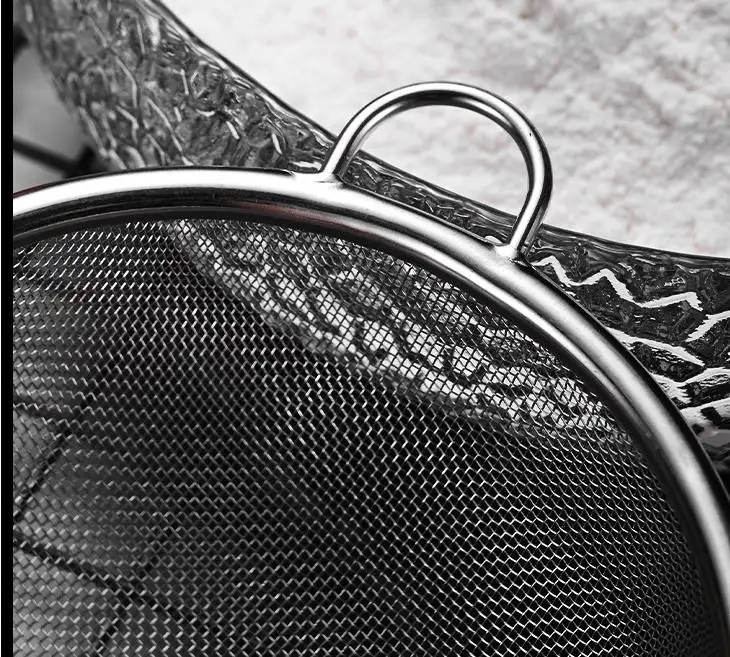 zoom-sita-gaica-strecuratoare-inox.jpg Zoom pe sita din inox și gaica de agățare a strecurătorului, evidențiind detaliile fine ale materialului și funcționalitatea de depozitare