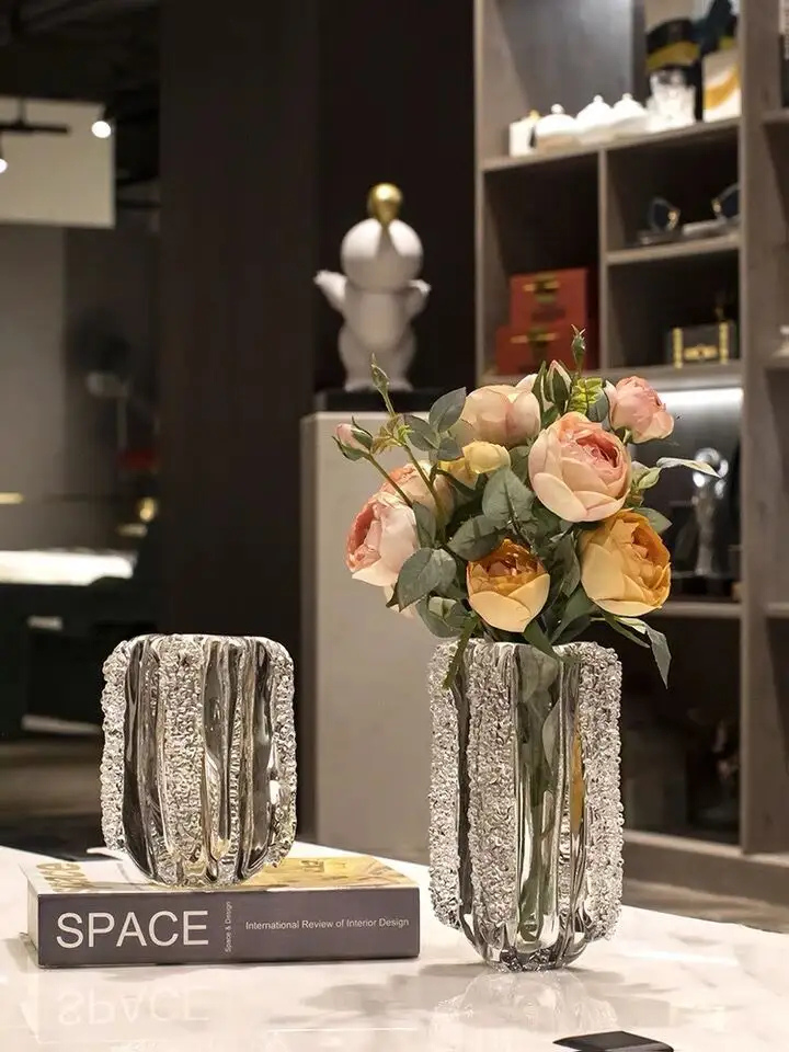 Set de două vaze decorative din sticlă texturată, una cu flori piersică și galbene, pe o masă elegantă