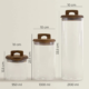 Set de 3 borcane din sticlă cu capac din lemn, goale, cu dimensiuni de 950ml (13.5*10 cm), 1300ml (23.5*10 cm) și 2300ml (33.5*10 cm), perfecte pentru depozitarea alimentelor.