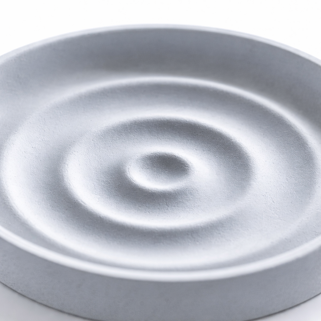 Design cu efect de unde – săpunieră din piatră de diatomit Detaliu săpunieră din piatră de diatomit cu design concentric tip unde pentru drenajul apei